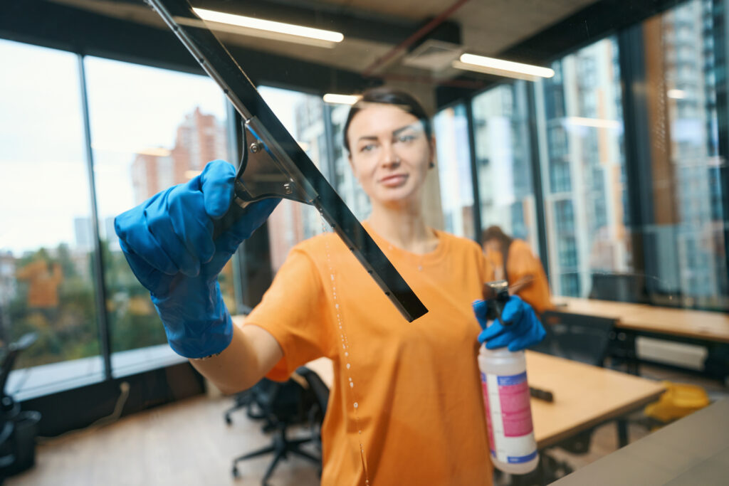 Cleaning business worker uses a special glass scraper